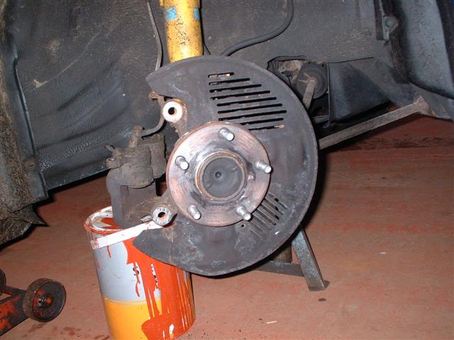 large paint tin supporting brake calliper weight
